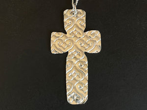 Silver cross pendant on a black background | Jewellery Classes