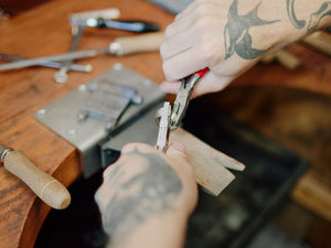 Person using pliers on a wooden workbench with tools | Jewelry Pliers