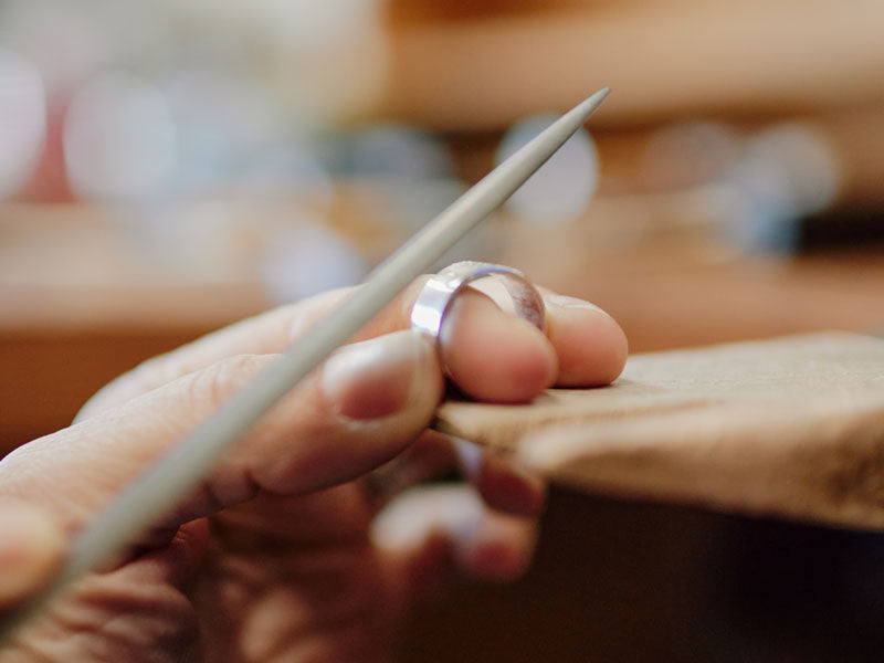 Close-up of a hand holding a half round file with a blurred background | Australian Jewellery Supplies