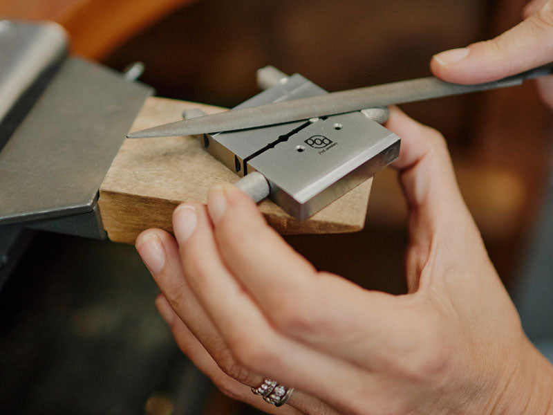 Person using a mitre vice jig on a wooden block with a blurred background | jewellery Supplies Sydney
