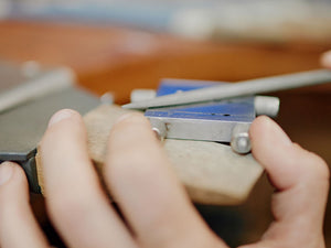 Close-up of hands using a mitre vice jig with a hand file on a wooden surface | Australian jewellery Supplies
