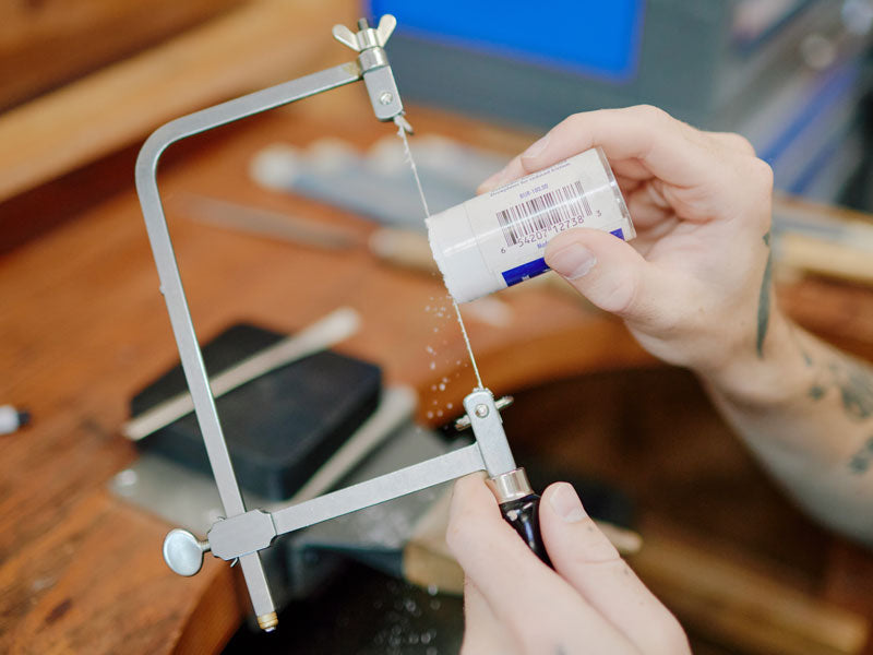 Person using a jewellers saw and applying lubrication to the blade | Australia Jewellery Supplies