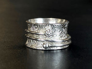 Silver spinner ring with embossed designs on a black background | 925 Silver