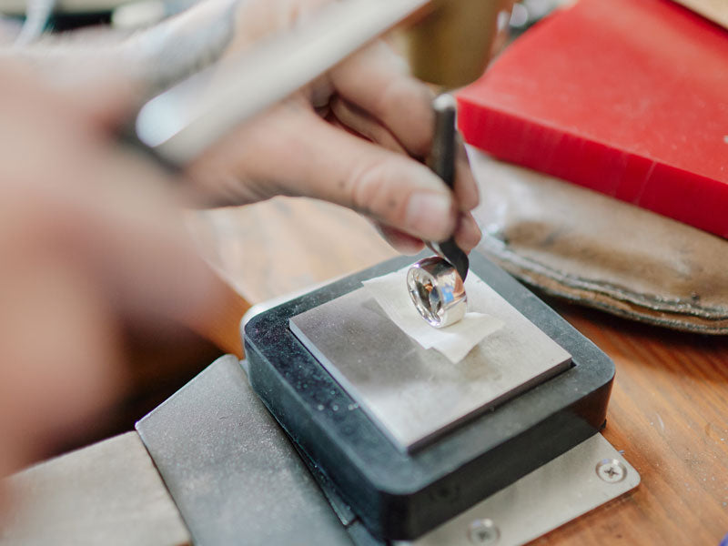 Person stamping a hallmark on a silver ring with a hallmarking punch | 925 hallmark stamp
