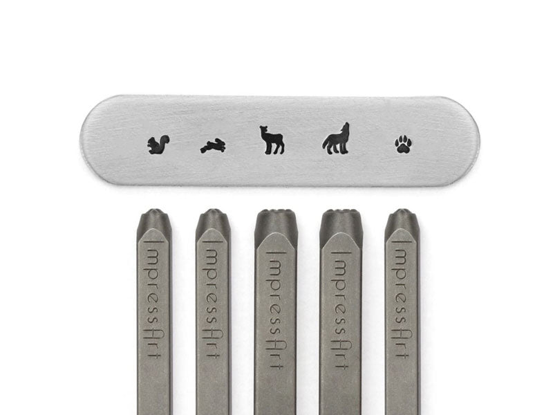 A set of five metal stamps with impressArt Forest Friends Signature Stamp Pack designs, including an animal and a paw print.