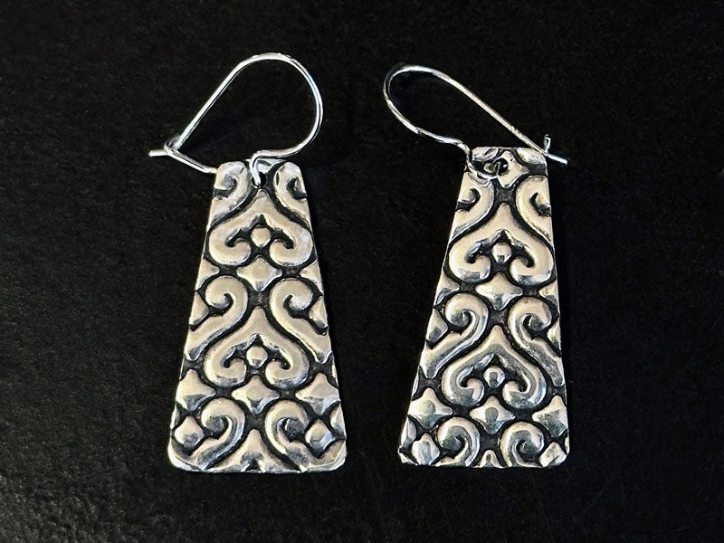 Pair of 925 silver patterned earrings oxidised with Liver of Silver Gel on a black background | Jewellery classes